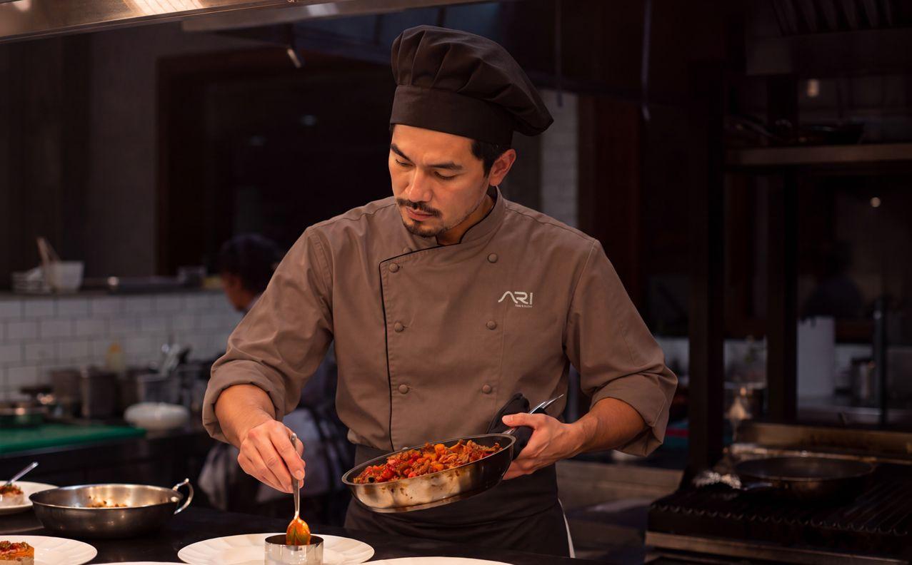 ARI's chef plating a dish at the open kitchen pass
